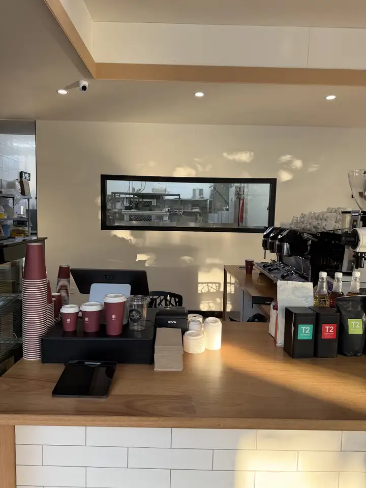 The coffee counter with the espresso machine and takeaway cups