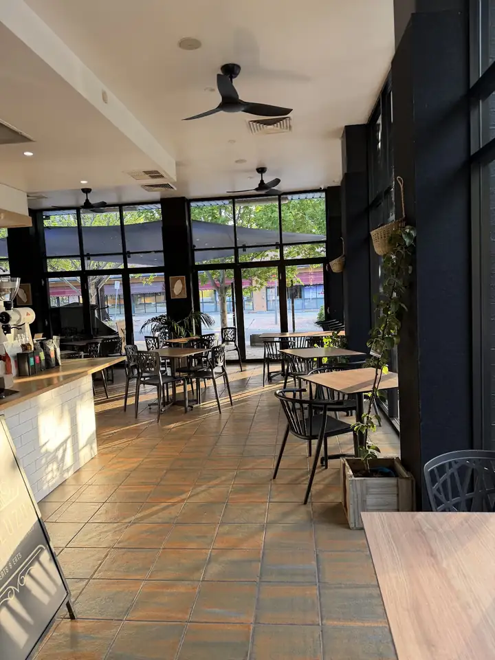 Tables and chairs inside the café beside big windows